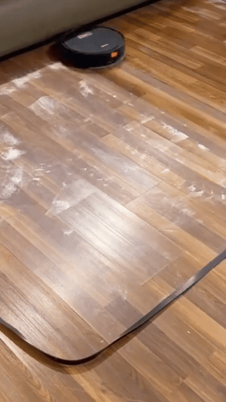 Mini robot aspirador limpiando el piso de un living moderno
